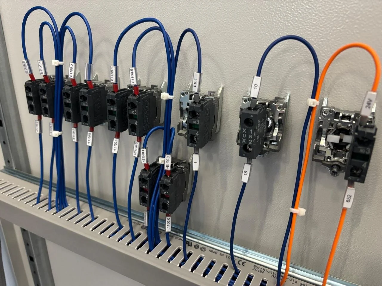 Cablaggio ordinato di pulsanti e contatti all'interno di un quadro elettrico industriale